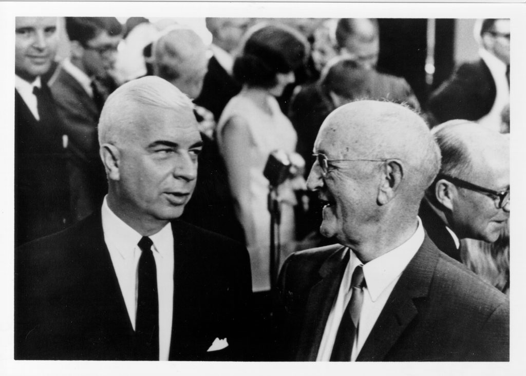 Black and white photograph of two men in a crowd.