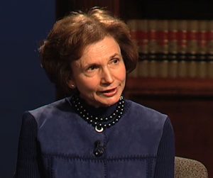 Barbara Milano Keenan speaking during the March 2013 interview with five 1985 Court of Appeals judges. She is seated in front of a book case.