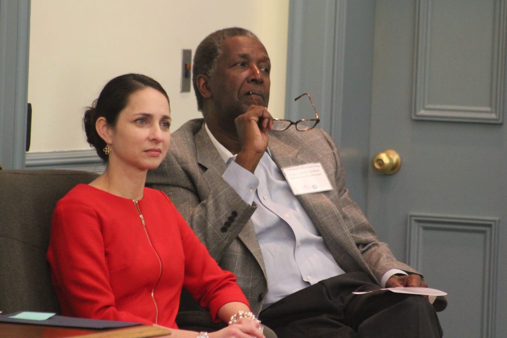 Hon. Uley N. Damiani is seated to the left of Hon. Nolan Dawkins. Judge Damiani is wearing a red dress and Judge Dawkins is wearing a sports coat and button-down holding glasses.